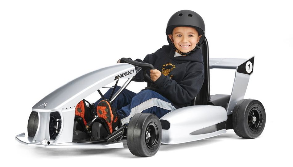 Child in a helmet driving an electric kart